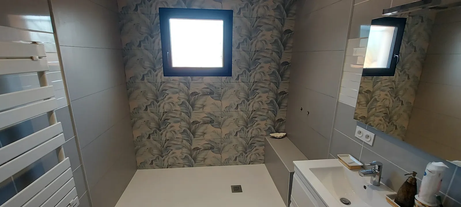 Douche à l'italienne avec un mur en carrelage décor à motif végétal