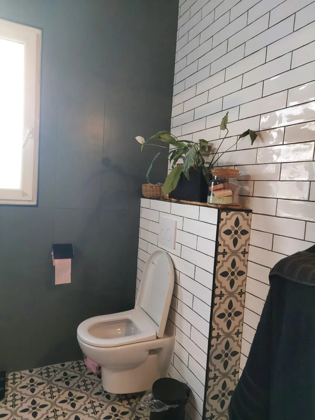 WC suspendu avec mur en carrelage métro blanc et sol en carreaux de ciment